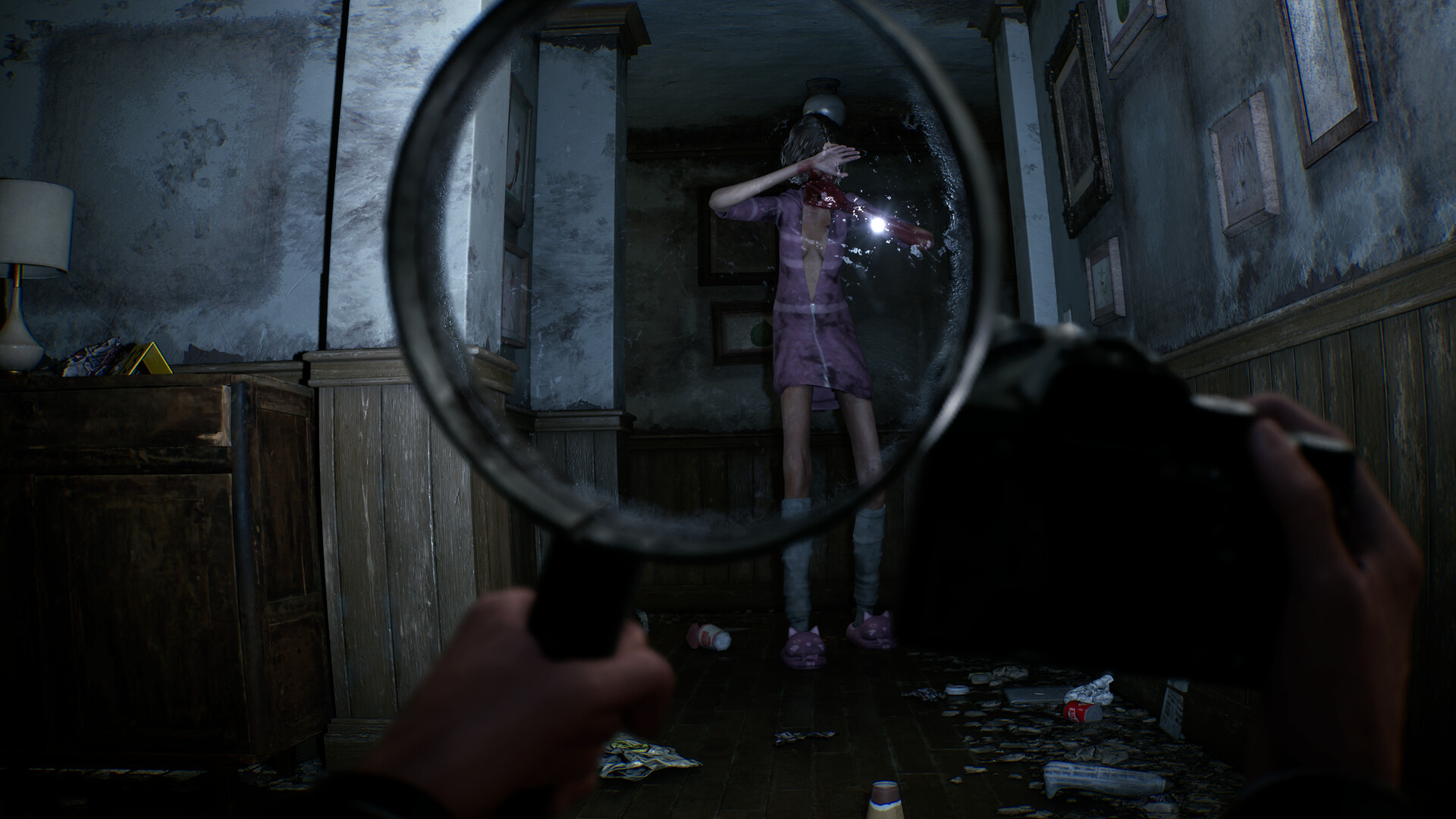 The player holds the camera and magnifying glass while tracking a paranormal figure.